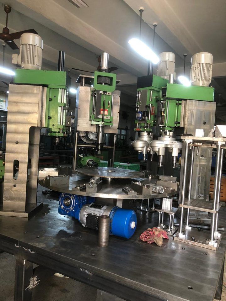 Multi-spindle rotary drilling machine with rotary table and multiple heads
